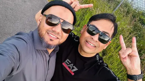 Mohammad Hasan Raish Ahmed, right, with his friend Mohammad Hasan. Both are wearing sunglasses and are looking up at the camera