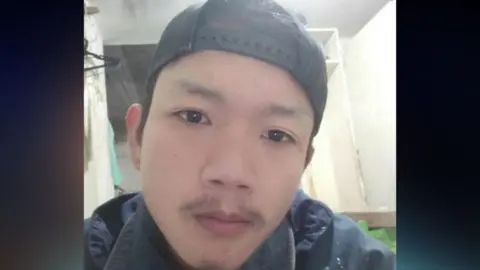 Hostages and Missing Families Forum Sonthaya Akrasri pictured wearing a backwards baseball cap and a blue coat