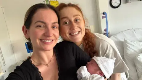 Georgia Barrington Georgia holding a newborn baby and Daisy 