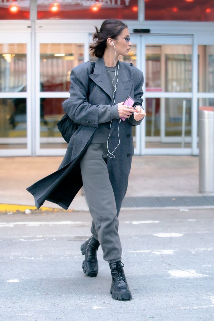 Supermodel Bella Hadid with wired earphones, tiny shades, and a phone in hand. (Image: Pinterest/zzarashamss)