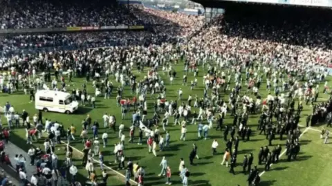Hillsborough inquests An ambulance and football fans and police officers on the pitch during the Hillsborough stadium disaster.