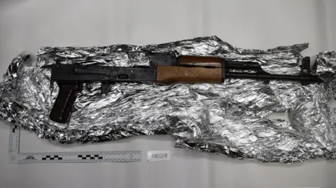 Greater Manchester Police A rifle that was recovered from the vehicle when Saadaoui was arrested, it is on top of tinfoil on a white background