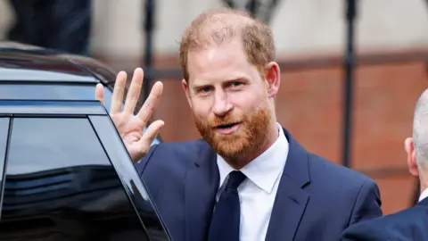 EPA Prince Harry waves as he steps from the door of a black car