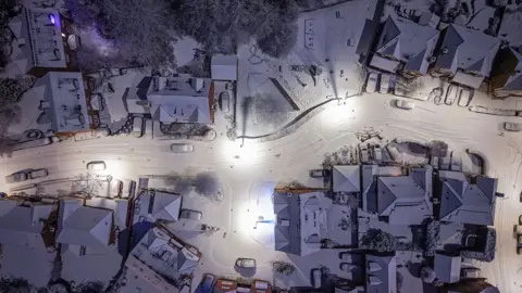 Getty Images Snow and sub-zero temperatures envelope homes in Northwich, Cheshire on Monday in an aerial image - showing streets and rooftops covered in white.